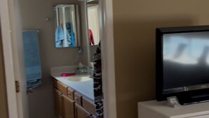 Une salle de bain avec un lavabo, un miroir et un porte-serviettes.