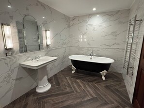 A bathroom with a pedestal sink, a freestanding bathtub, and a mirror above the sink. - Luxury 2 Bedroom, 2 Bath Executive Retreat (Hamilton)