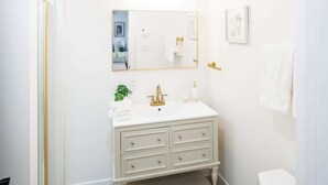 Et hvidt badeværelse med et toiletbord, et spejl og et toilet.