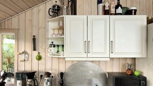 Een keuken met witte kastjes, een koffiezetapparaat, een broodrooster en een magnetron.