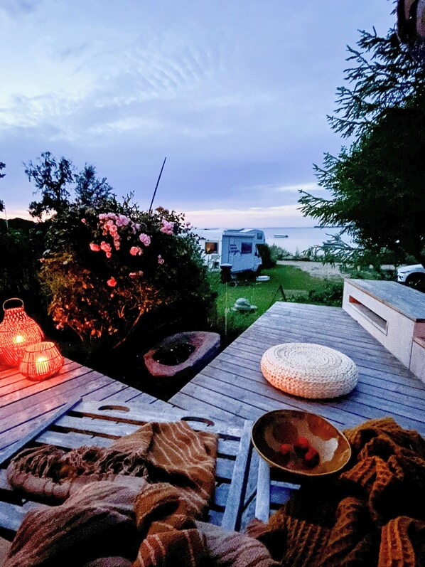 A deck with a blanket, a woven pouf, and a lantern. - Summerhouse by the Little Belt with sea view (Haderslev)