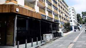Een hotel met meerdere verdiepingen, uitgevoerd in modern design, met balkons voorzien van metalen hekwerk en een vlakke gevel.
