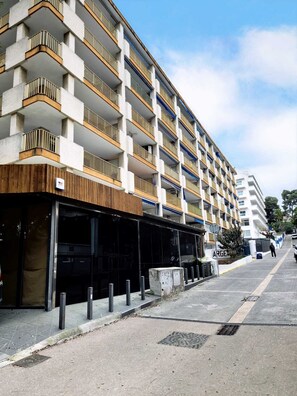 A multi-story hotel with a modern design, featuring balconies with metal railings and a flat facade. - Pigem Apartment (Salou)