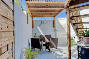 A covered patio with wicker furniture and potted plants. - Liyann - Proche plage - Terre Sainte (Saint-Pierre)
