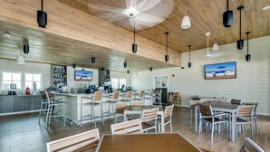 A spacious indoor area with a bar, seating, and a television. - New Listing! Lost Key San Andres| Two pools| Private Beach Club| Tennis| Free Golf Round Daily! (Pensacola)