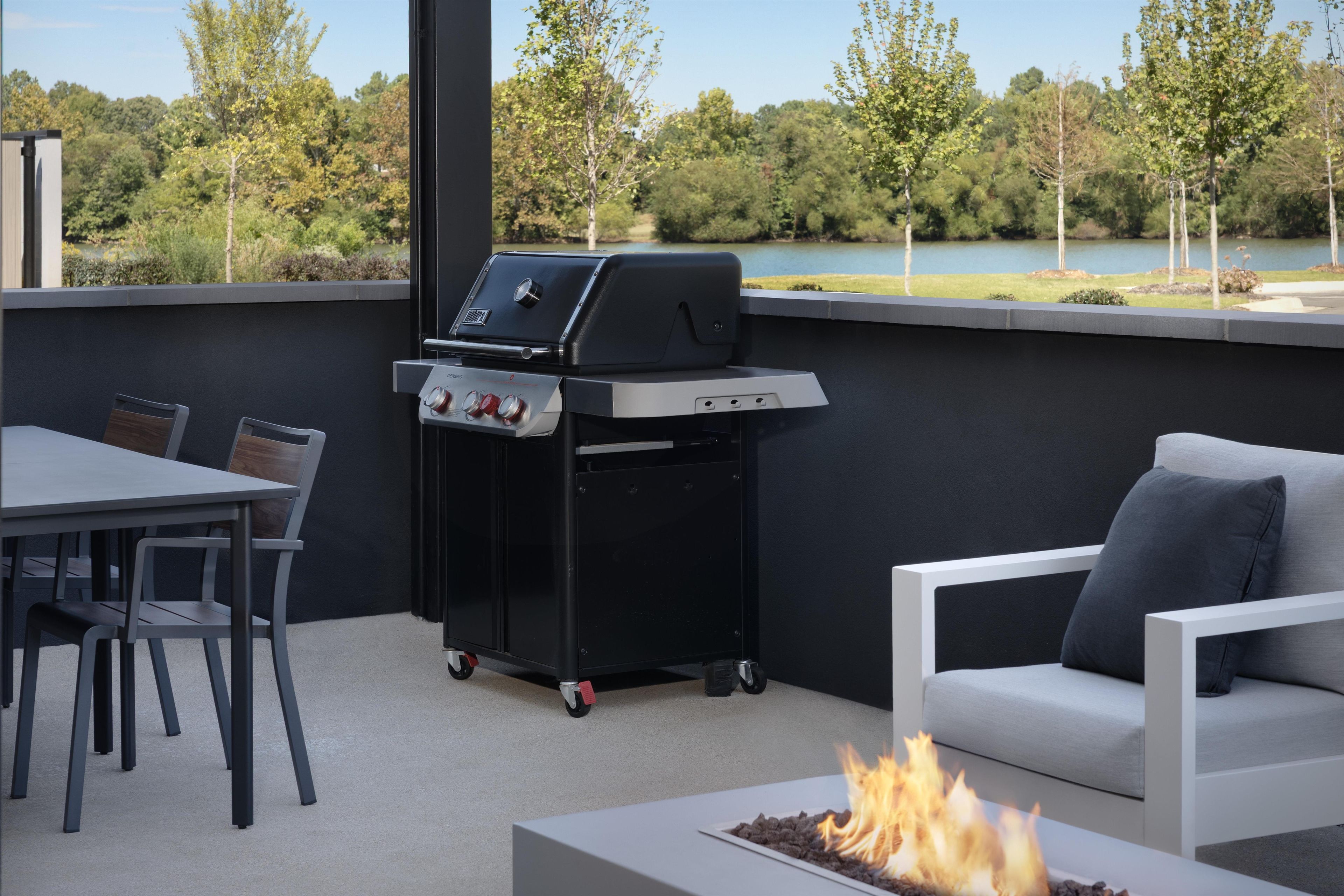 An outdoor patio with a grill, seating, and a fire feature.