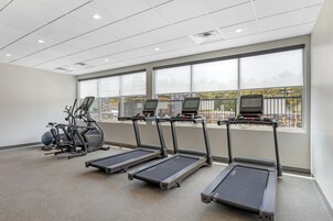 Un gimnasio equipado con cintas de correr, elíptica y bicicleta estática.