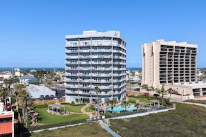 A multi-story hotel with balconies, a swimming pool, and a view of the ocean. - Aquarius by South Padre Resort Rentals (South Padre Island)