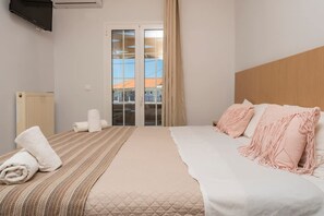 Ein Hotelzimmer mit Bett, Heizkörper, Fernseher und einer Schiebetür.