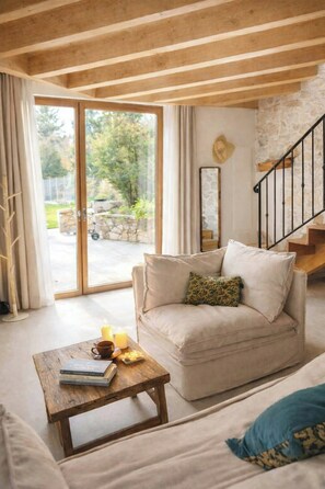 Ein gemütliches Wohnzimmer mit einer Couch, einem Couchtisch und einer Treppe.