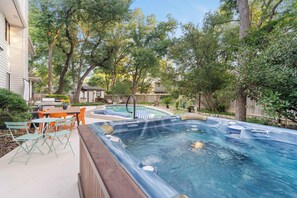 Ein Garten mit Whirlpool, Sitzgelegenheiten im Freien und einem Swimmingpool.