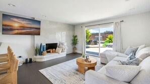 A modern living room with a fireplace, a large window, and a view of the outdoors. - Harbor Isle Beauty - Minutes To Huntington Beach (Huntington Beach)