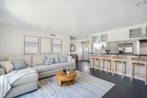 A modern living room with a sofa, coffee table, and artwork on the wall. - Harbor Isle Beauty - Minutes To Huntington Beach (Huntington Beach)