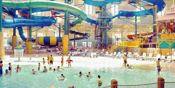 Parque acuático interior con múltiples toboganes y piscinas.