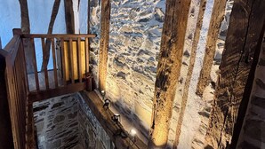 A stone wall with wooden beams and a wooden staircase.