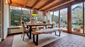 Interior em madeira com uma mesa de jantar, cadeiras e um banco.