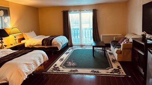 Une chambre d’hôtel avec deux lits, un canapé, une télévision et une grande fenêtre avec des rideaux.