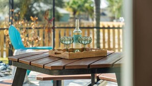 A wooden picnic table with a bottle and two glasses on a tray. - 2170 Myla Ln (Melbourne)