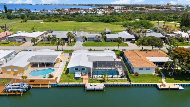 Un quartiere residenziale con case, una piscina e un molo con barche.