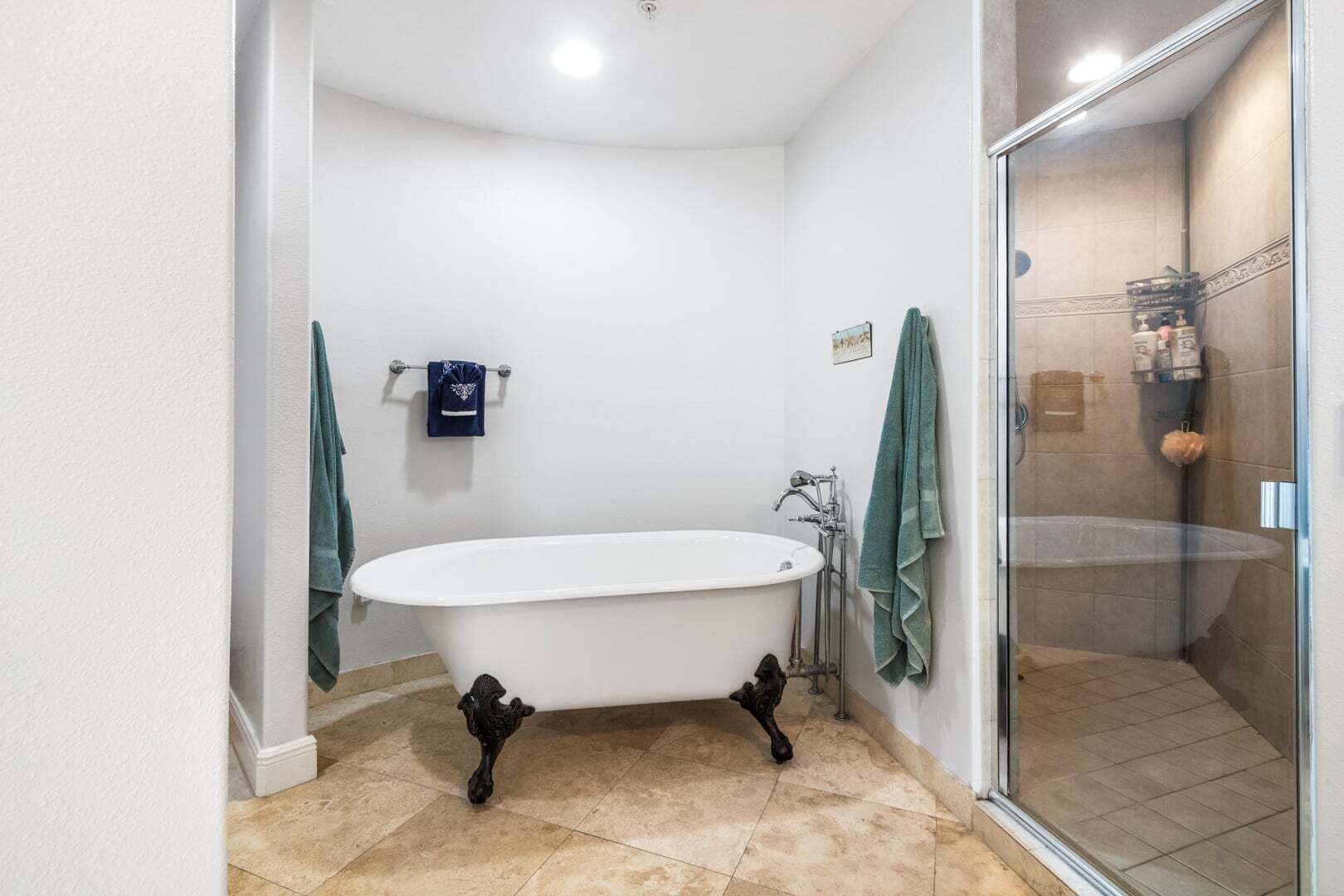 A bathroom with a freestanding bathtub, a glass shower enclosure, and a tiled floor.