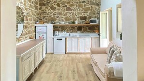 Una cocina con paredes de piedra, encimera de madera y una lámpara colgante.