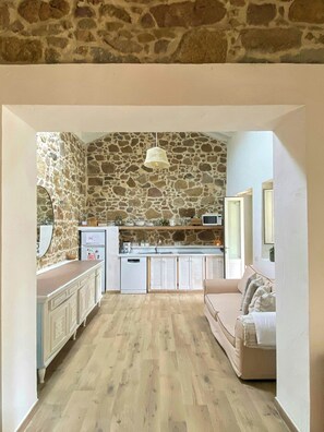 Eine Küche mit Steinwänden, einer Holz Arbeitsplatte und einer Pendelleuchte.