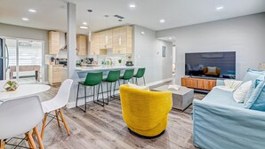 Een moderne woonkamer met een gele fauteuil, een blauwe bank en een televisie.
