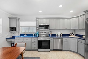 Eine moderne Küche mit grauen Schränken, einem Edelstahlbackofen und einer blauen Arbeitsplatte.