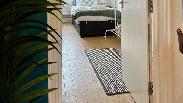 Ein Schlafzimmer mit Bett, Nachttisch und einem Fenster mit Vorhängen.