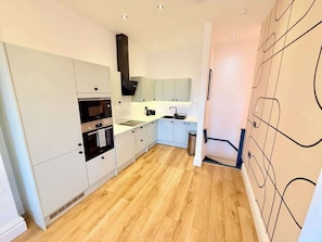 A modern kitchen with white cabinetry, a built-in oven, and a sink. - Central - Free parking- Sleeps 6 - Stylish Apt (Saint Paul's)