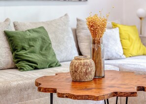 Ein Couchtisch aus Holz mit einer Vase und einer dekorativen Glasur, platziert auf einer Couch mit verschiedenen Kissen.