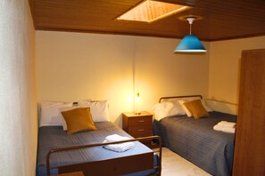 A room with two beds, a wooden ceiling, and a blue pendant light. - Lourença Stays – Casa Castro Sernancelhe (Sernancelhe)
