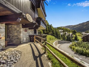 A mountain lodge with a stone facade, wooden balcony, and a sign indicating a restaurant. - Fermes de Méribel Delys #2D2 - 6 guests - Ski in - Ski out (Les Allues)