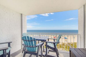 A balcony with a view of the beach, featuring a table and chairs. - Super Clean, Pool, Beach, Dining, Fun (Orange Beach)