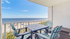 Ein Balkon mit Blick auf Strand und Meer.