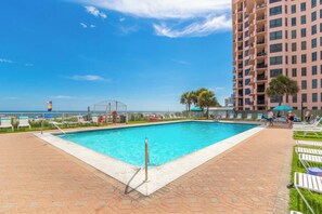 A rectangular swimming pool with a metal ladder, surrounded by a paved walkway and lounge chairs. - Super Clean, Pool, Beach, Dining, Fun (Orange Beach)