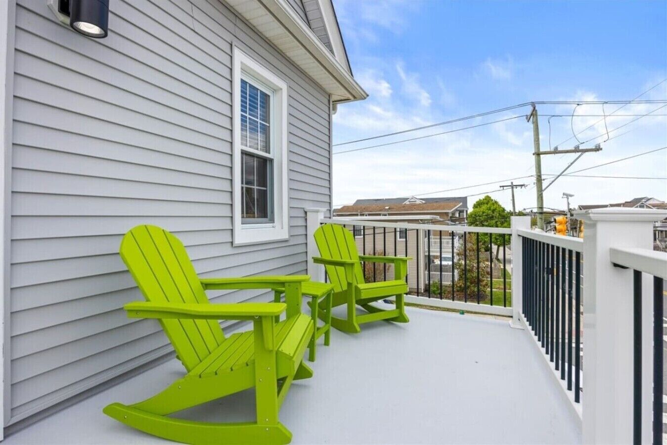 A porch with two rocking chairs and a white railing.