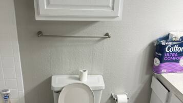 Een haardroger, handdoeken, zeep, toiletpapier