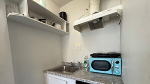 A compact kitchen with a sink, a microwave, and a dishwasher. - Comfortable Studio Unit on 2nd Floor (Los Angeles)