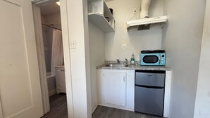 A compact kitchen with a microwave, dishwasher, and a small countertop. - Comfortable Studio Unit on 2nd Floor (Los Angeles)