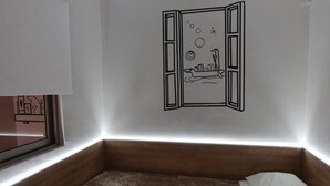 Un dormitorio con cama, ventana y un adhesivo mural de barco.