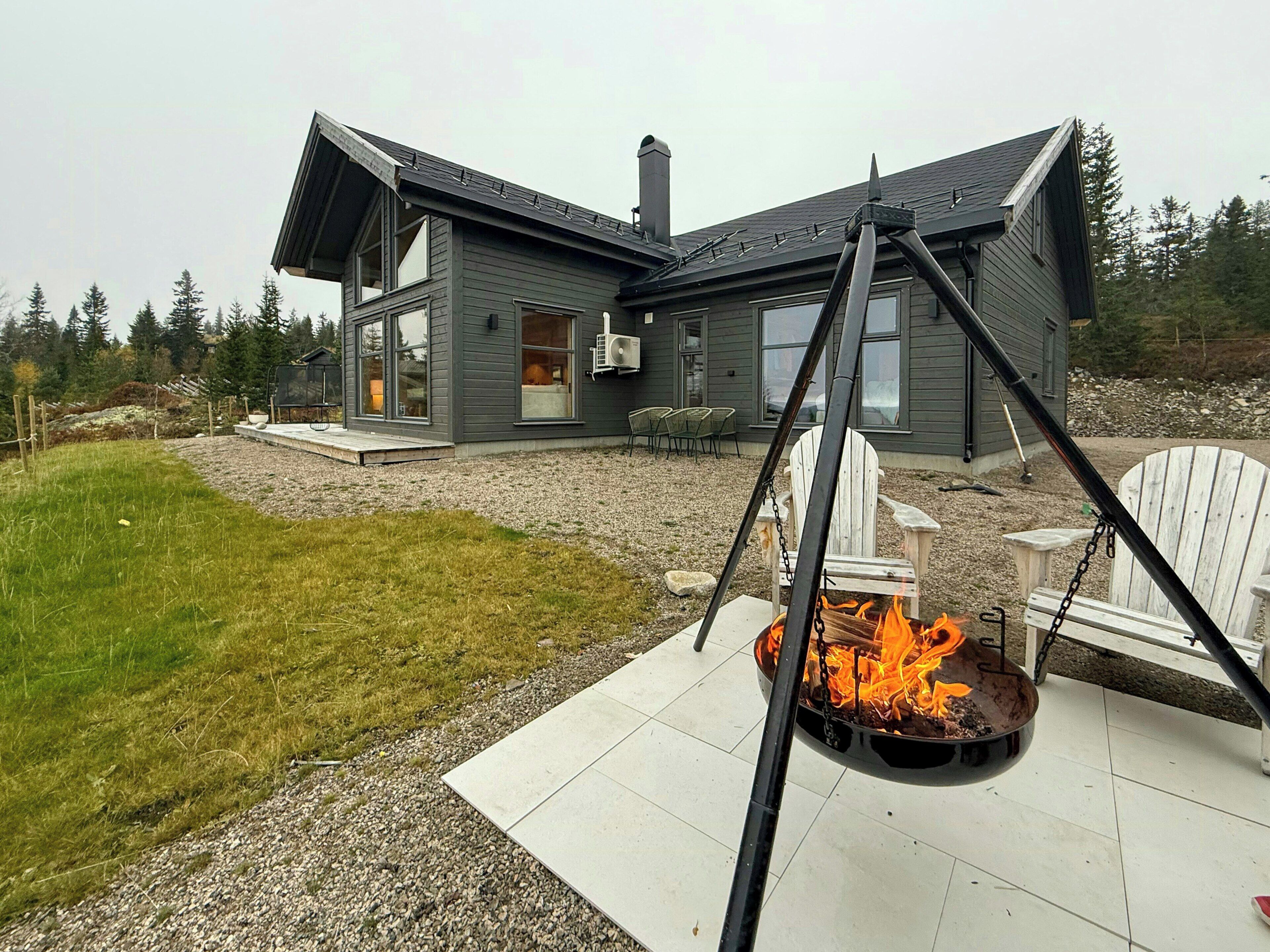 Une maison moderne avec un foyer extérieur dans le jardin.