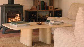 Ein gemütliches Wohnzimmer mit Kamin, Bücherregal und bequemer Couch.
