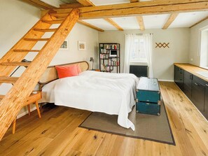 A bedroom with a wooden ladder, a bed, a bookshelf, and a desk. - Experience the Uckermark from the old hayloft (Weggun)