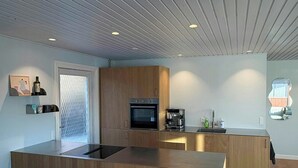 Una cucina moderna con mobili in legno, forno integrato e forno a microonde.