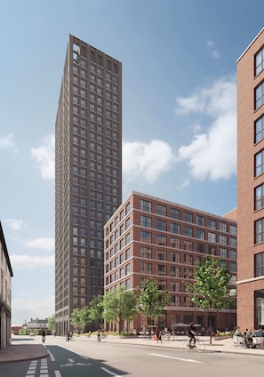 A modern urban street with high-rise buildings, a bike lane, and outdoor seating areas. - Spacious Family Stay in Southside | StayCozy (Birmingham)