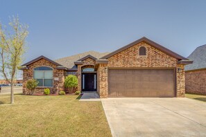 A single-story brick house with a garage, a front door, and a small porch. - Bogey`s House - 3BR/2BA Brand New Listing (Lubbock)