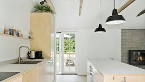 Eine moderne Küche mit Holztresen, Edelstahlgeräten und Pendelleuchten.