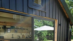 A modern kitchen with a large sliding glass door leading to an outdoor patio. - Design house with garden in the heart of Småland (Gullabo)