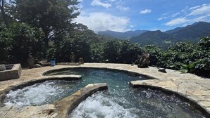 Un'area con sorgenti termali, gradini in pietra e vista sulle montagne.
